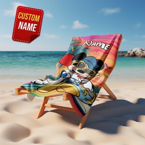 Puede incluir: Una silla de playa con una toalla colorida con un personaje de dibujos animados con gafas de sol. La toalla tiene la palabra "NAME" impresa. Una etiqueta roja con las palabras "CUSTOM NAME" est&aacute; en la esquina superior izquierda.