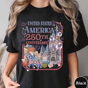 Puede incluir: Camiseta negra con un gr&aacute;fico colorido que celebra el 250 aniversario de los Estados Unidos de Am&eacute;rica. El dise&ntilde;o incluye personajes de dibujos animados, un castillo y elementos patri&oacute;ticos.