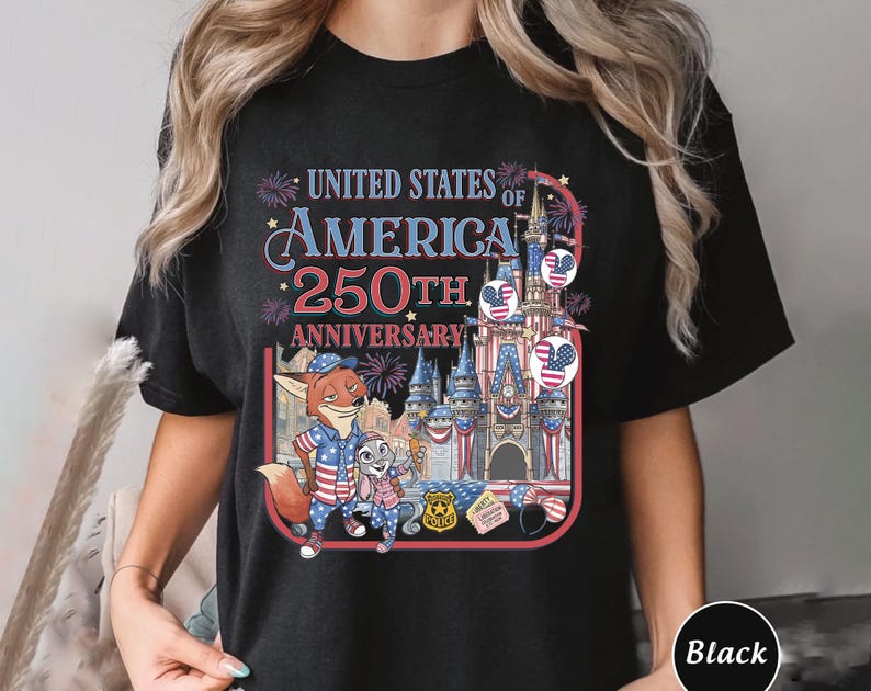 Puede incluir: Camiseta negra con un gr&aacute;fico colorido que celebra el 250 aniversario de los Estados Unidos de Am&eacute;rica. El dise&ntilde;o incluye personajes de dibujos animados, un castillo y elementos patri&oacute;ticos.