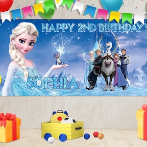 Puede incluir: Una pancarta de cumplea&ntilde;os con personajes de la pel&iacute;cula Frozen, con el texto "HAPPY 2ND BIRTHDAY!" y el nombre "SOPHIA". La escena incluye globos, cajas de regalo y un coche de juguete.