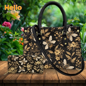 May include: A black handbag and matching wallet set with a bee and floral pattern. The bag has a top handle and a shoulder strap. The wallet has a zipper closure. The background features the text "Helio Prints".