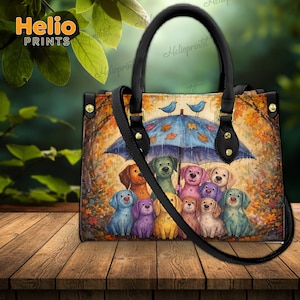 以下が含まれることがあります： 青い傘の下にいる犬たちのカラフルなイラストが特徴のトートバッグ。秋の葉と2羽の青い鳥が描かれています。バッグには黒いハンドルとショルダーストラップがあり、上部には「Helio PRINTS」の文字があります。