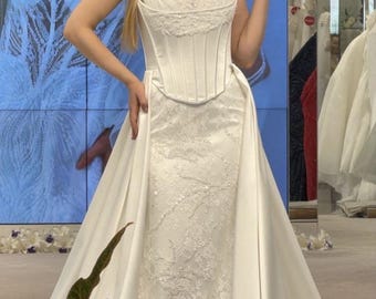 Abito da sposa in raso elegante con spacco, scollo a barca e dettaglio delicato sul busto – Modello 2026