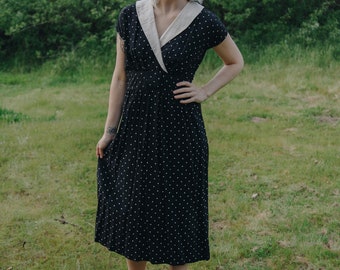 50's style vintage women's black and white polka dot midi dress with oversized v-neck collar, cinched waist zipper closure, 80's era