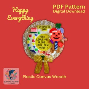 Könnte beinhalten: Ein Kranz aus Plastik-Canvas mit einem farbenfrohen Design mit den Worten "Happy Everything" und "Groundhog Day". Der Kranz enthält auch einen Kürbis mit einem Gesicht, einer Krawatte und einem Herzen. Der Kranz ist mit einer gelben Schleife verziert.