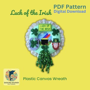 May include: A green plastic canvas wreath with a white lace trim. The wreath features a shamrock, horseshoe, pot of gold, leprechaun, and a sign that says "Luck of the Irish".