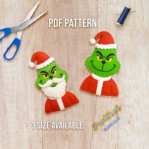 Puede incluir: Dos adornos de fieltro con temática de Grinch en rojo, verde y blanco, con el texto "PDF PATTERN" y "3 SIZE AVAILABLE". También hay unas tijeras con mango azul y una bobina de hilo.