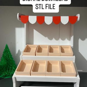 Peut inclure: Un étal de marché miniature avec un cadre blanc et des étagères beiges. L'étal a un auvent festonné rouge et blanc et le texte "TÉLÉCHARGEMENT NUMÉRIQUE FICHIER STL" et "Miniature Market Stall".