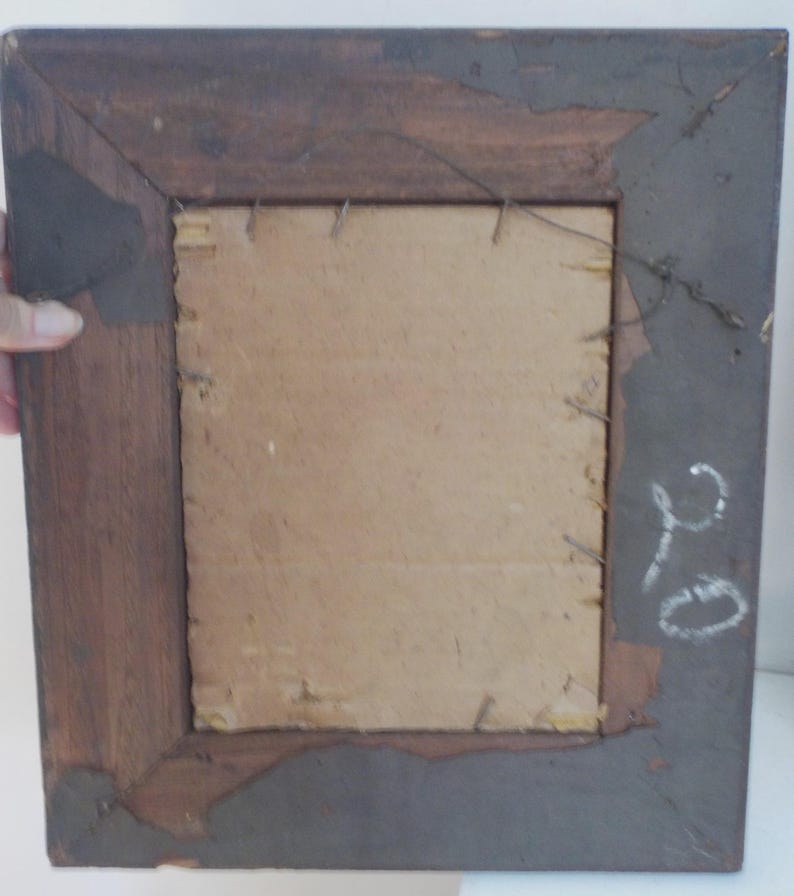 K&ouml;nnte beinhalten: Ein dunkelbrauner Holzbildrahmen mit einem Kartonr&uuml;cken. Der Rahmen hat ein schlichtes Design und ist in gutem Zustand. Auf der R&uuml;ckseite des Rahmens ist eine handgeschriebene Nummer "210" mit wei&szlig;er Kreide.