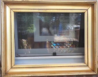 May include: A rectangular picture frame with a metallic gold finish. The frame features a wide, smooth, slightly curved profile with thin, raised decorative beading along the inner edge. The surface shows minor signs of wear and light scuffing.