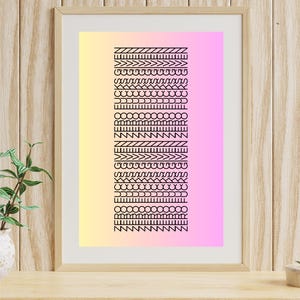 May include: Framed art print featuring a gradient background of yellow and pink. The print displays a series of black geometric patterns. The frame is a light wood color, and the artwork is displayed on a wooden surface.