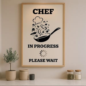 May include: A framed print with a black and white illustration of a chef's hat and a frying pan with food flying out of it. The text reads "Chef in Progress Please Wait" with a loading icon.