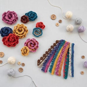 May include: A collection of handmade crochet flowers in various colors, including pink, red, blue, and yellow. Also shown are crochet edging samples, wooden buttons, and balls of yarn in neutral tones. Craft supplies for a DIY project.