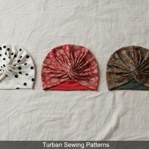 May include: Three turbans featuring a front knot detail. The first is white with black polka dots. The second is red with a white paisley pattern. The third is dark green with a multi-colored floral paisley print. Text reads Turban Sewing Patterns.