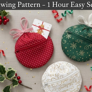 May include: Three round, zippered pouches in red polka dot, green snowflake, and white script patterns. Each pouch has a ribbon loop and zip closure. The image includes holly, berries, and decorative ribbons, suggesting a festive theme.