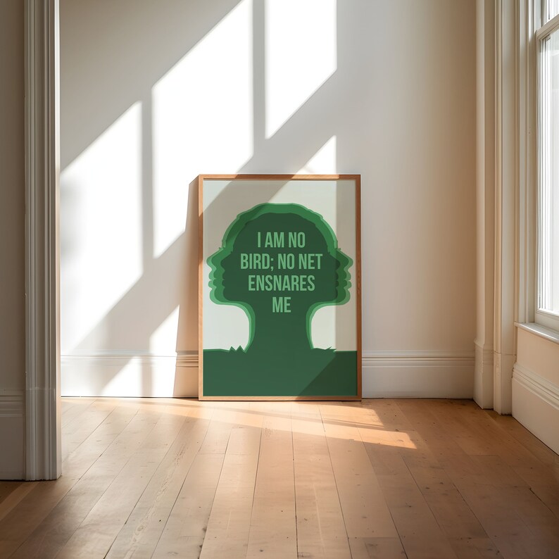 May include: A framed art print featuring a green silhouette of a tree-like figure with the text "I AM NO BIRD; NO NET ENSNARES ME." The artwork is set against a light background, with a wooden frame. The print is displayed on a wooden floor.