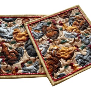 May include: Two quilted brown and beige placemats with a red trim and a pattern of colorful chickens and roosters.