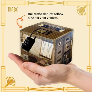 May include: A puzzle box with a combination lock, held in a hand. The box is decorated with a vintage design, featuring a map, drawers, and the text "Die Ma&szlig;e der R&auml;tselbox sind 10 x 10 x 10cm". The box measures approximately 3.9 x 3.9 x 3.9 inches.