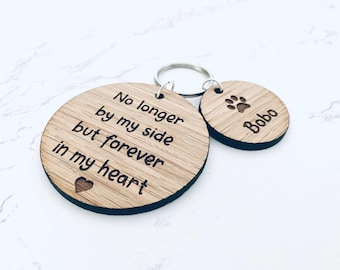 Puede incluir: Juego de llaveros de madera con dos colgantes redondos. El colgante más grande tiene el texto "No longer by my side but forever in my heart" y un corazón. El colgante más pequeño tiene una huella de pata y el nombre "Bobo".