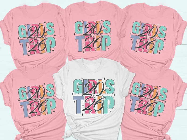 a collection of pink t-shirts with the text "GIRLS TRIP" printed on them.