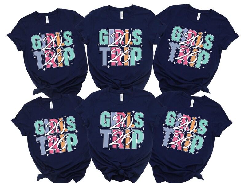 six navy blue t-shirts with the text "GIRLS TRIP" printed on them in a colorful, stylized font.