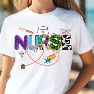 May include: White t-shirt with the word "NURSE" spelled out in colorful letters. The letters are decorated with medical symbols, including a stethoscope, a bandage, a syringe, and pills.