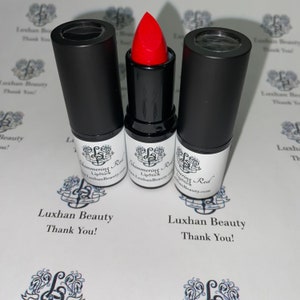 May include: Three black lipstick tubes with a red lipstick bullet. The lipstick is labeled "Shimmering Red Lipstick" and "Luxhan Beauty.com".