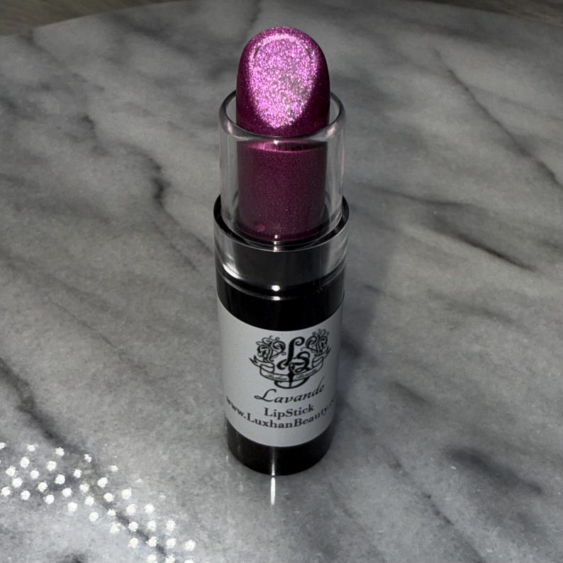 May include: A pink lipstick tube with a silver shimmer finish. The tube is labelled "Lavande Lipstick" and "www.LuxhanBeauty.com".