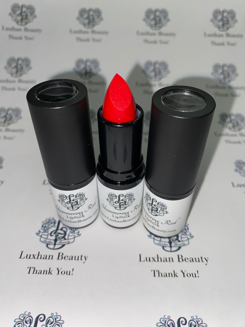 May include: Three black lipstick tubes with clear tops. The middle tube has a red lipstick bullet. The label on the tubes reads "Shimmering Lipstick" and "Luxhan Beauty".