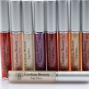 May include: A set of ten silver lip gloss tubes with clear and shimmery glosses inside. The tubes are labeled "Luxhan Beauty Lip Gloss".