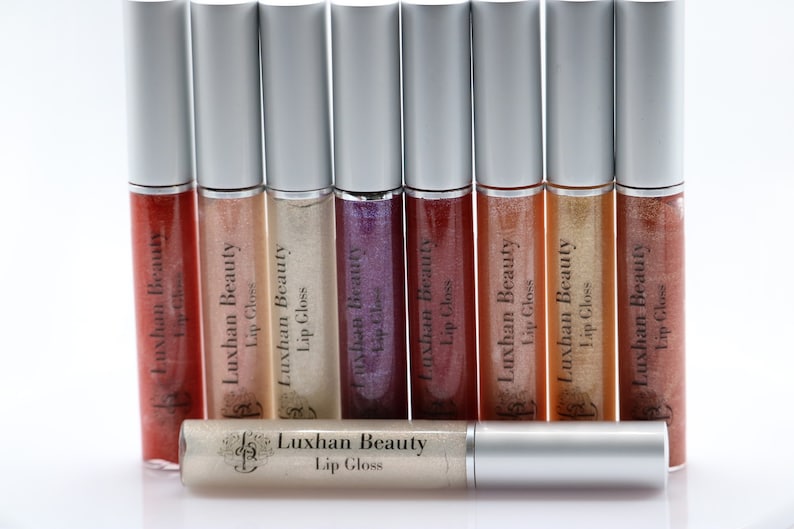 May include: A set of ten silver lip gloss tubes with clear and shimmery glosses inside. The tubes are labeled "Luxhan Beauty Lip Gloss".