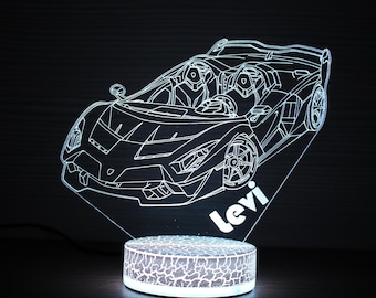 May include: A white outline of a sports car is illuminated by a light. The car design is on a clear, angled panel, with the name "levi" in white. The base is a textured, circular shape with a glowing effect.