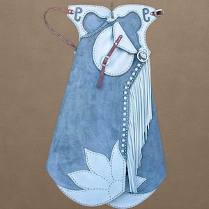 Könnte beinhalten: Blaue Lederchaps mit weißen Akzenten, darunter ein Blumenmuster, Fransen und dekorative Nähte. Mit einem braunen Lederriemen und Schnallen. Western-Bekleidung.