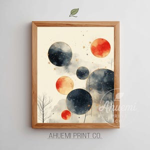 May include: A framed art print featuring a watercolor design of celestial orbs in shades of navy, orange, and gold. The artwork includes a light beige background with a few bare trees and the text "AHUEMI PRINT CO."