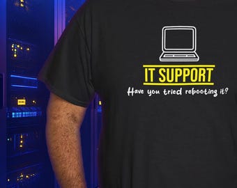 Op de afbeelding: Zwart T-shirt met een wit laptop-icoon en de tekst "IT SUPPORT Have you tried rebooting it?"