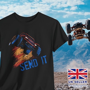 Peut inclure: T-shirt noir avec un graphique rouge, bleu et orange d'un monster truck faisant un wheelie. Le texte "SEND IT" est imprimé en bleu sous le camion.