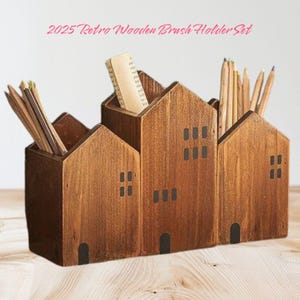 Puede incluir: Un organizador de escritorio de madera con forma de fila de casas. El organizador tiene cuatro compartimentos, cada uno con un diseño diferente. El organizador está hecho de madera marrón y tiene detalles negros.