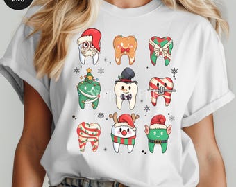 May include: White t-shirt featuring a festive dental-themed design. The design includes various cartoon teeth decorated with holiday elements like Santa hats, bows, and ornaments. The words "INSTANT DOWNLOAD" are at the bottom.