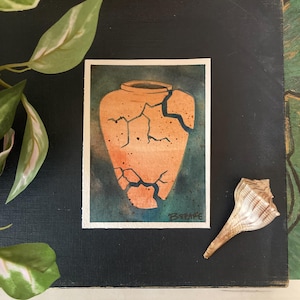 Può includere: Acquerello di un vaso di terracotta crepato su sfondo scuro. Il vaso è di colore arancione caldo con crepe scure. Una conchiglia è appoggiata accanto al dipinto. Il dipinto è firmato "B.RPARE".