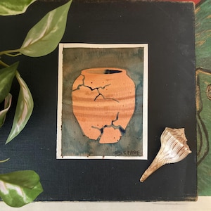 May include: Watercolor painting of a cracked terracotta pot with a dark blue interior, set against a teal and dark blue background. The artwork is signed "S. SPARE". A seashell rests on the right side of the painting.