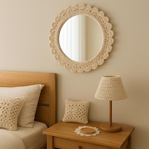 May include: A bedroom with a crocheted mirror, lamp, and throw pillows. The mirror has a round shape and a white crocheted frame. The lamp has a white crocheted shade and a wooden base. The throw pillows are also white and crocheted.