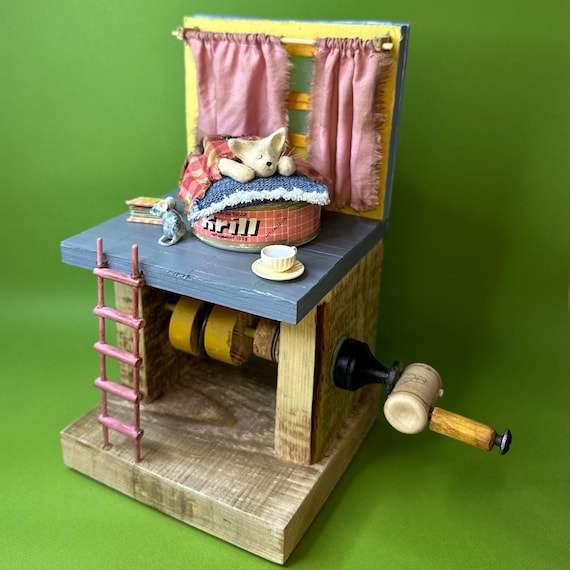 A hand-carved wooden automaton where a cat mechanically moves as you crank it — pure kinetic magic that belongs on a desk or shelf.
