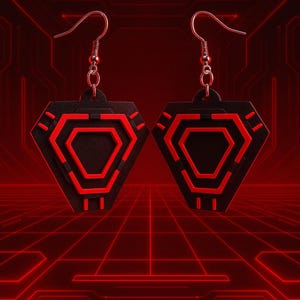 May include: A pair of black and red geometric earrings. Each earring features a black, diamond-shaped pendant with a red hexagonal design in the center. The earrings have silver-colored fish hook ear wires. The background is a red grid pattern.