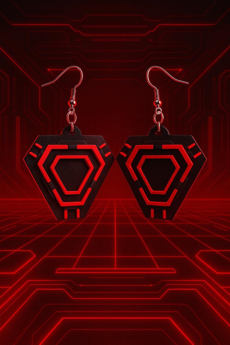 May include: A pair of black and red geometric earrings. Each earring features a black, diamond-shaped pendant with a red hexagonal design in the center. The earrings have silver-colored fish hook ear wires. The background is a red grid pattern.