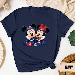 A navy blue t-shirt with a graphic of two cartoon mice wearing matching blue and red outfits, sitting next to each other.