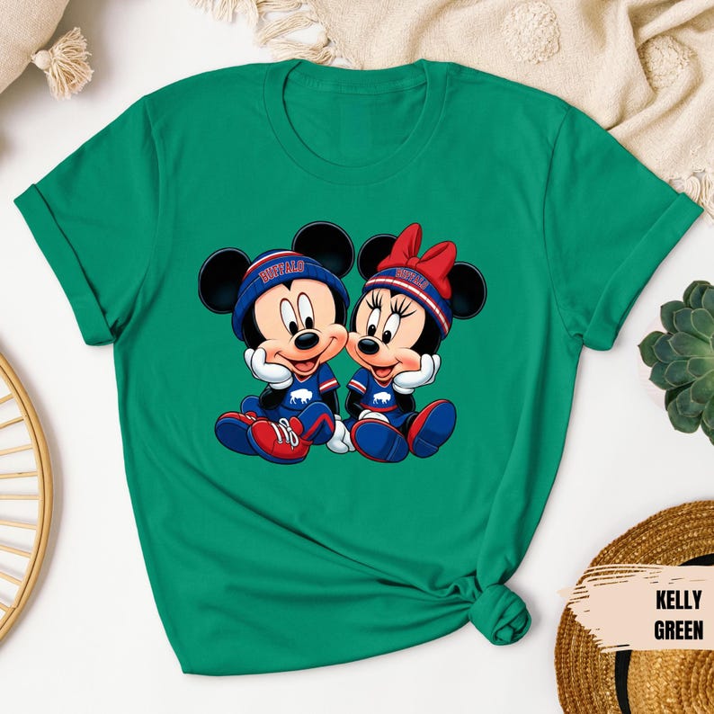 A green t-shirt with a graphic of two cartoon mice, Minnie Mouse and Mickey Mouse, sitting together.
