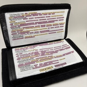 Könnte beinhalten: Eine schwarze Ledergeldbörse mit einem durchsichtigen Plastikfenster, das eine Liste von Getränken und Cocktails zeigt, die in verschiedenen Restaurants und Bars im Epcot, einem Themenpark in Orlando, Florida, erhältlich sind. Die Liste umfasst Getränke aus Ländern wie Italien, Frankreich, Japan, Marokko und Kanada.