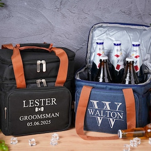 Peut inclure: Deux sacs isothermes, un noir et un bleu, avec des poignées marron. Le sac noir porte le nom "LESTER" et "GROOMSMAN". Le sac bleu porte le nom "WALTON". Les deux sacs sont remplis de bouteilles.