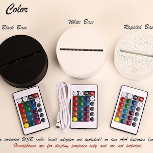 May include: A product display featuring three circular bases in black, white, and a cracked white finish. Each base has a slot for a light. Three remote controls with multi-colored buttons and a USB cable are also shown. The text "Base Color" is at the top.