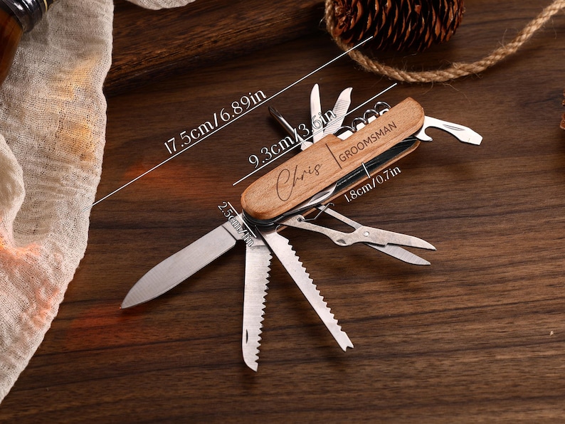 May include: A wooden-handled multi-tool knife with multiple blades and tools extended. The knife is 6.89 inches long and features the engraved name "Chris" and the word "Groomsman". The knife is on a dark wooden surface.